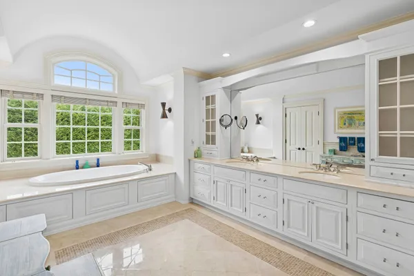 a large white bathroom with a large mirror vanity and a sink