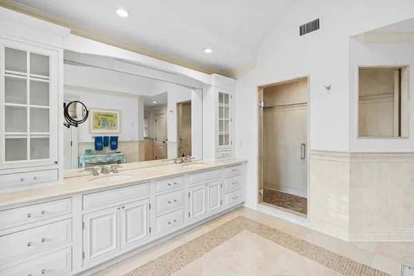 a spacious bathroom with double vanity a mirror a shower and a bathtub