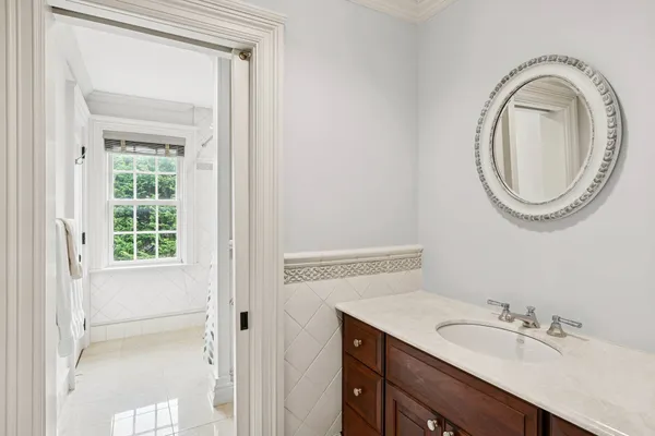 a bathroom with a granite countertop sink a mirror and a shower