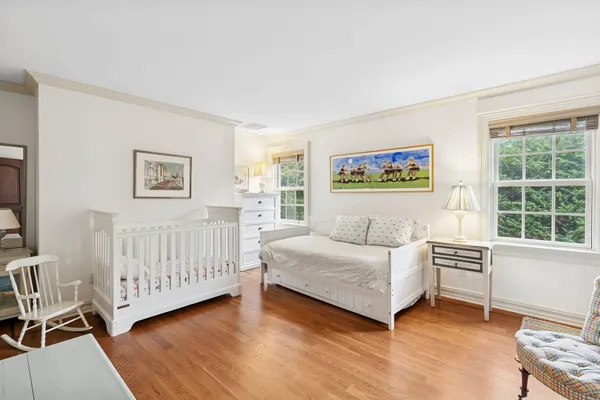 a living room with a baby crib furniture and a window