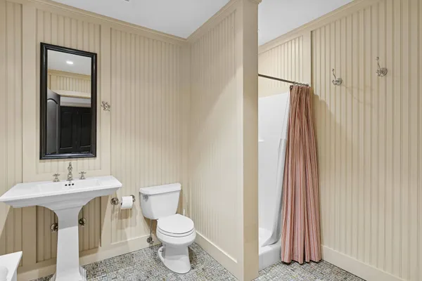 a bathroom with a toilet sink and a mirror