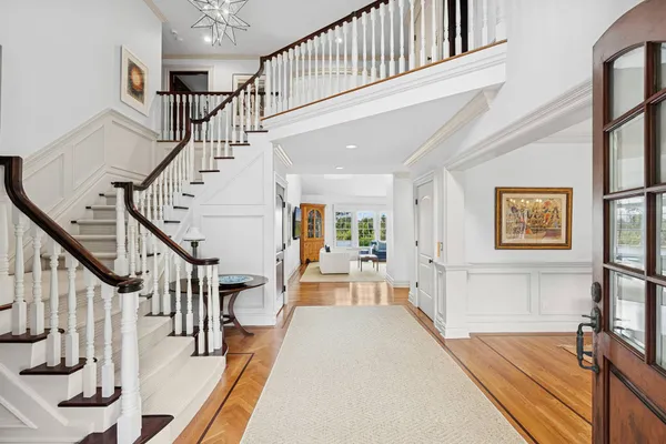 a view of a hallway with wooden floor and staircase