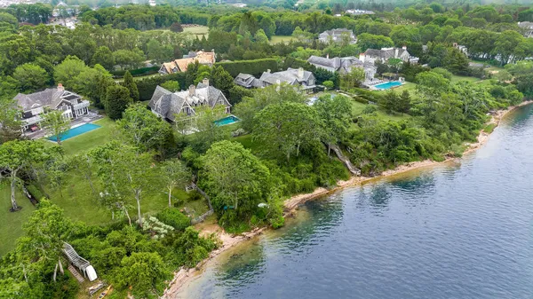 an aerial view of a house with a yard and lake view