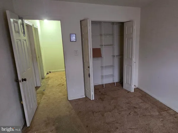 an empty room with an entryway and closet