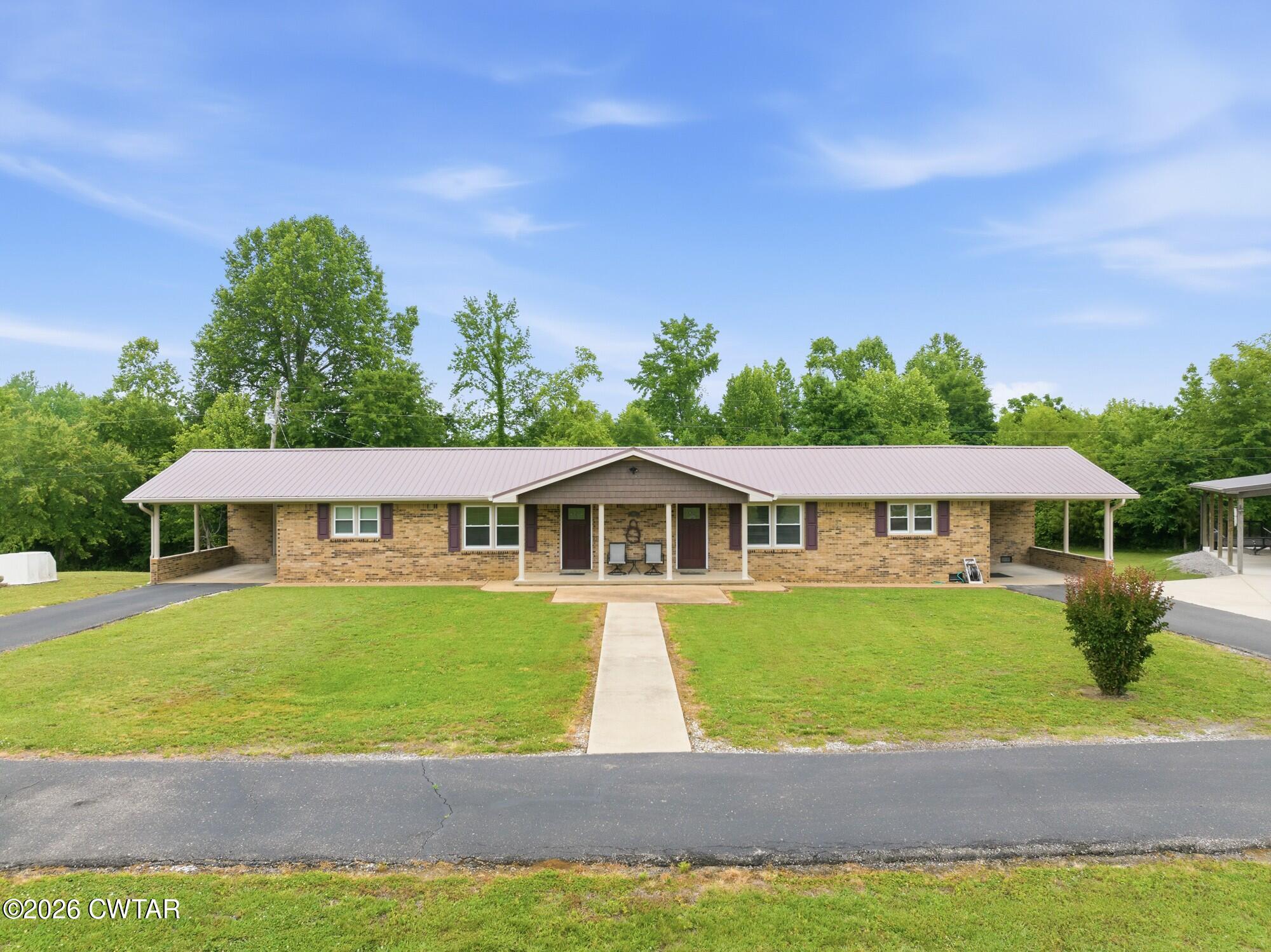 944 Brooksie Thompson Road Decaturville, TN 38329 - Photo 4 of 47 a front view of a house with a garden and yard