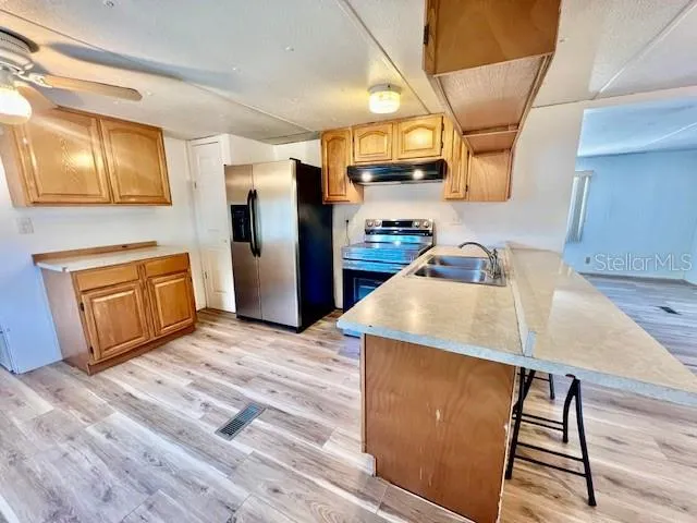 a kitchen with stainless steel appliances a stove a refrigerator and a sink