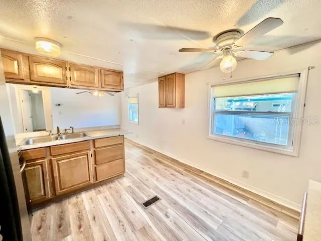 a kitchen with stainless steel appliances a refrigerator a sink and white cabinets