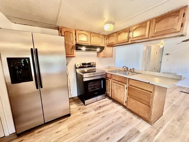 a kitchen with stainless steel appliances granite countertop a sink and a stove