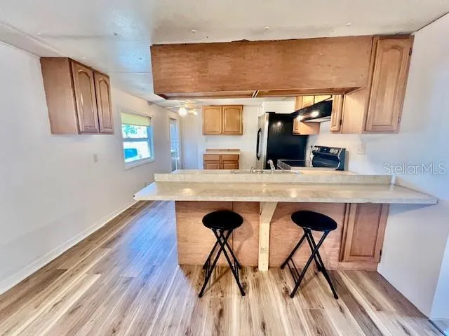 a kitchen with stainless steel appliances granite countertop a sink a stove and a refrigerator