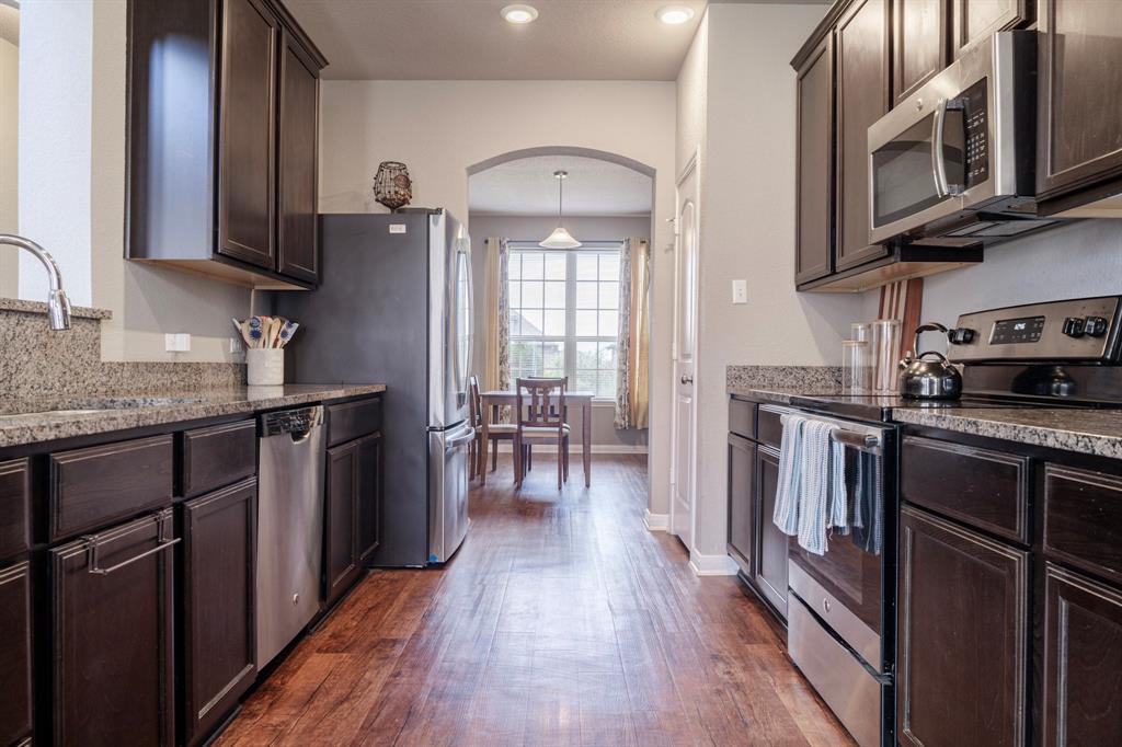 2716 Beutel Road Lorena, TX 76655 - Photo 10 of 39 a kitchen with stainless steel appliances granite countertop hardwood floor sink stove dining table and chairs