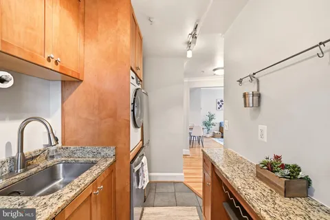 a kitchen with stainless steel appliances granite countertop a sink a stove and a refrigerator