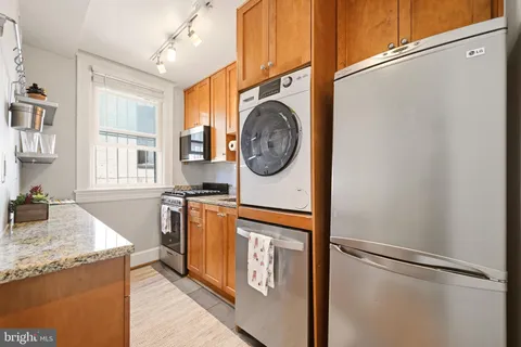 a utility room with granite countertop a sink a washer and dryer