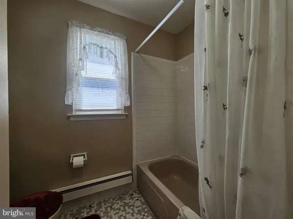a bathroom with a granite countertop bathtub shower and toilet