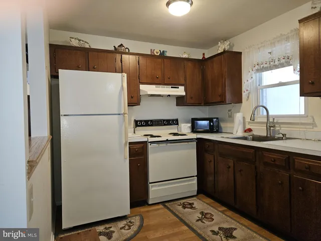 a kitchen with a refrigerator sink and cabinets