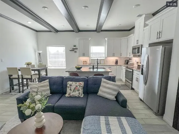 a living room with furniture wooden floor and a refrigerator
