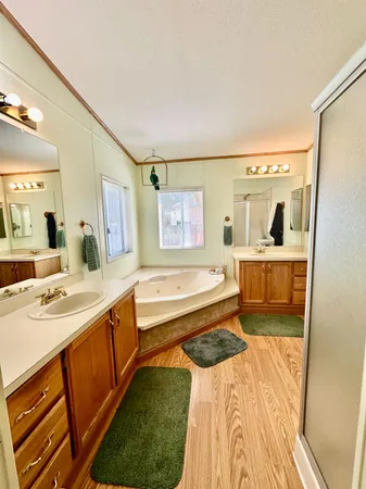 a spacious bathroom with a tub sink and mirror