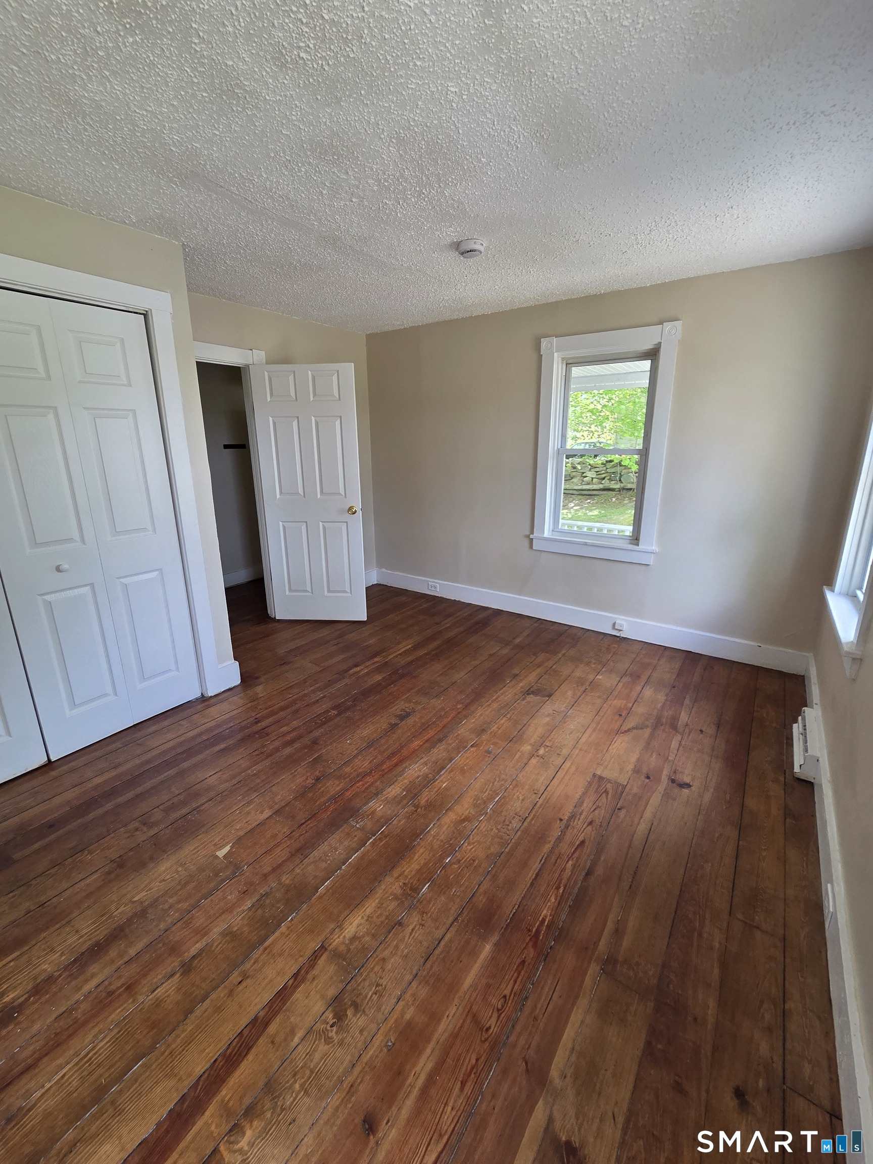 22 Lakeview Street, Unit 1 East Hampton, CT 06424 - Photo 5 of 20 an empty room with wooden floor and windows