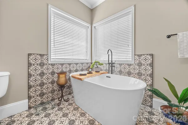 a white bath tub sitting in a bathroom next to a window