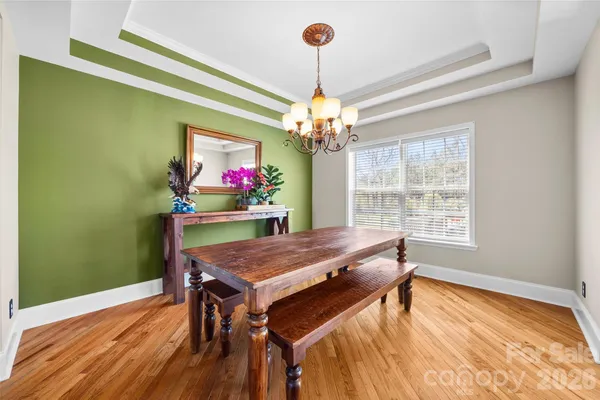 a dining room with furniture a chandelier and wooden floor