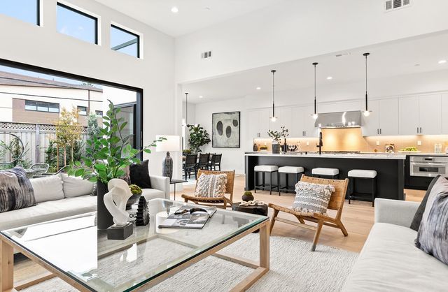 a living room with furniture kitchen view and large windows