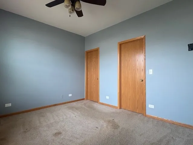 an empty room with closet and fan