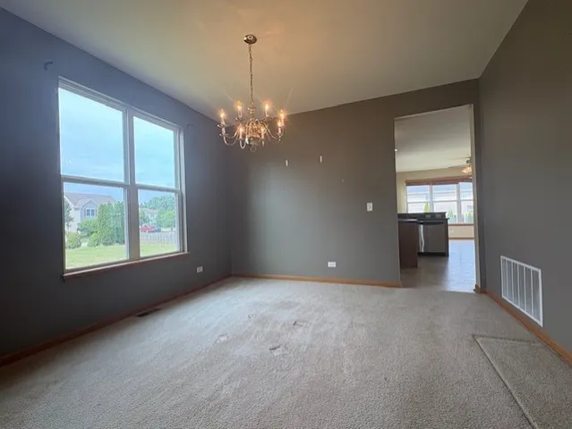 a view of an empty room with window and cabinet