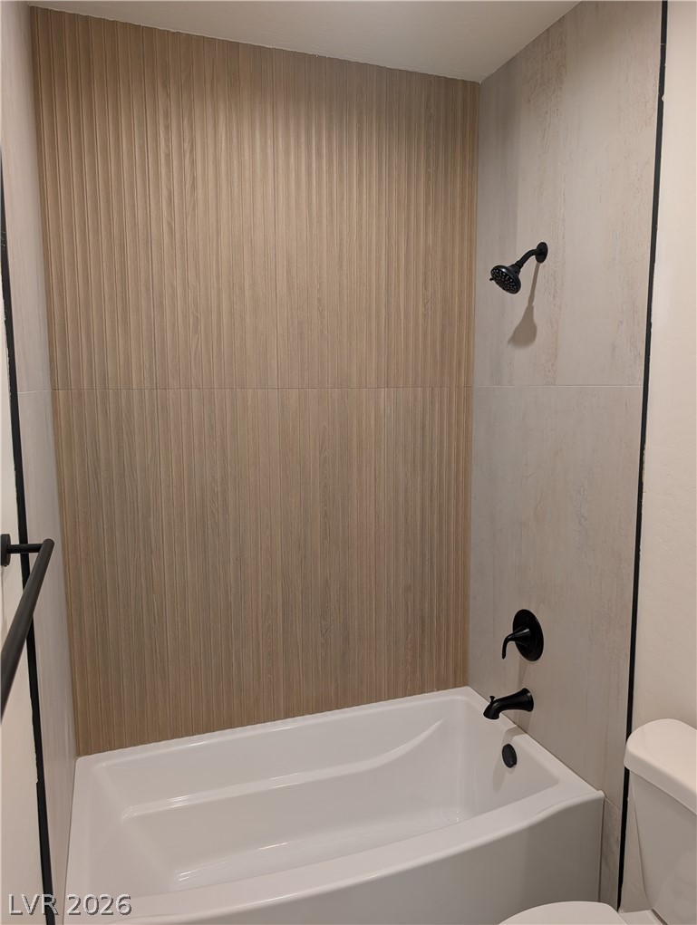 4670 Medicine Man Road Pahrump, NV 89048 - Photo 25 of 36 Modern bath with wood-look tile and sleek black fixtures.