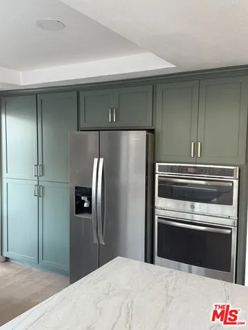 a kitchen with granite countertop stainless steel appliances and refrigerator