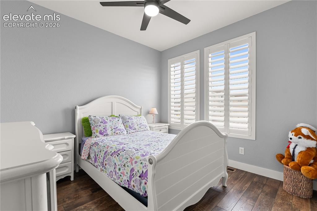 12781 Granite Ridge Drive Peyton, CO 80831 - Photo 24 of 41 Main level bedroom that is bright with a ceiling fan and plantation shutters.