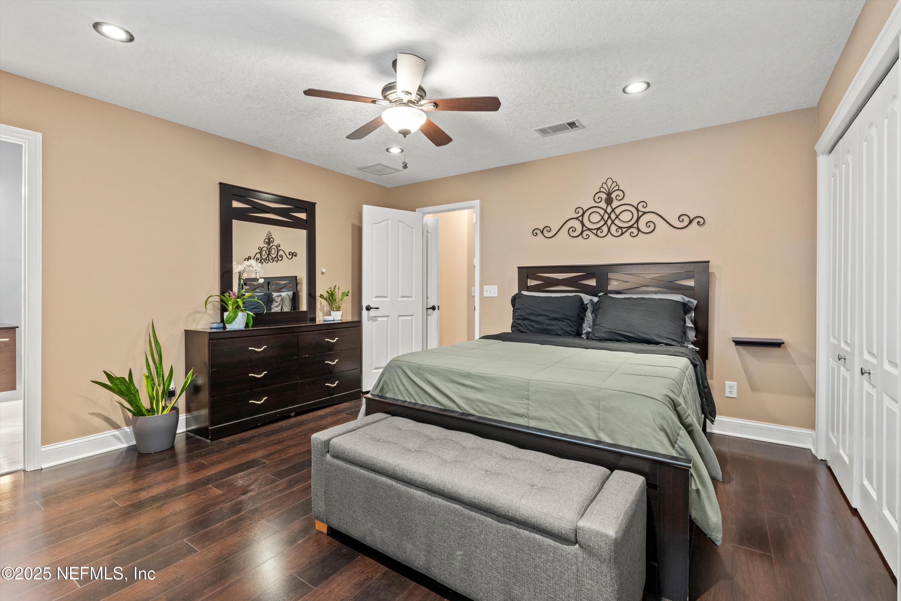 4807 Evenlode Lane Jacksonville, FL 32217 - Photo 13 of 28 a bedroom with a bed and wooden floor