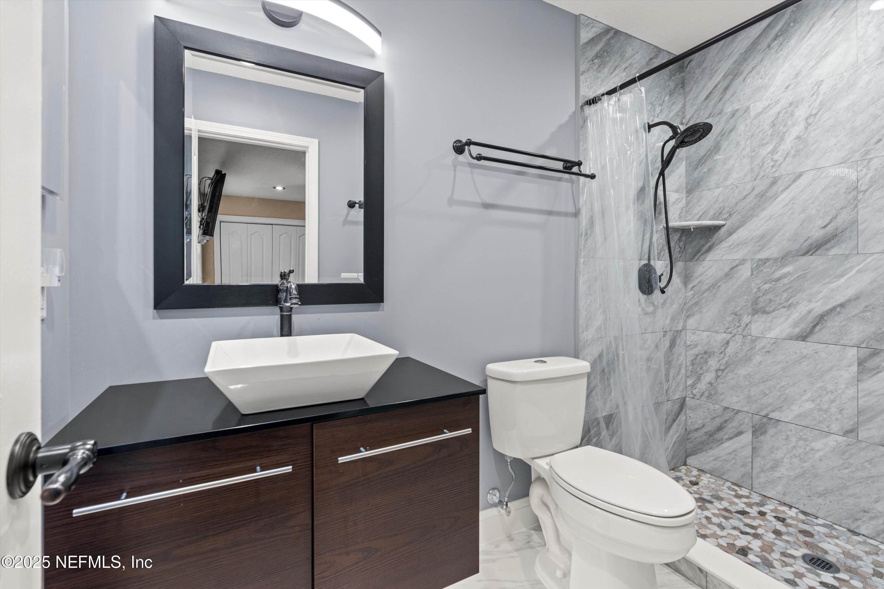 4807 Evenlode Lane Jacksonville, FL 32217 - Photo 14 of 28 a bathroom with a toilet sink and mirror