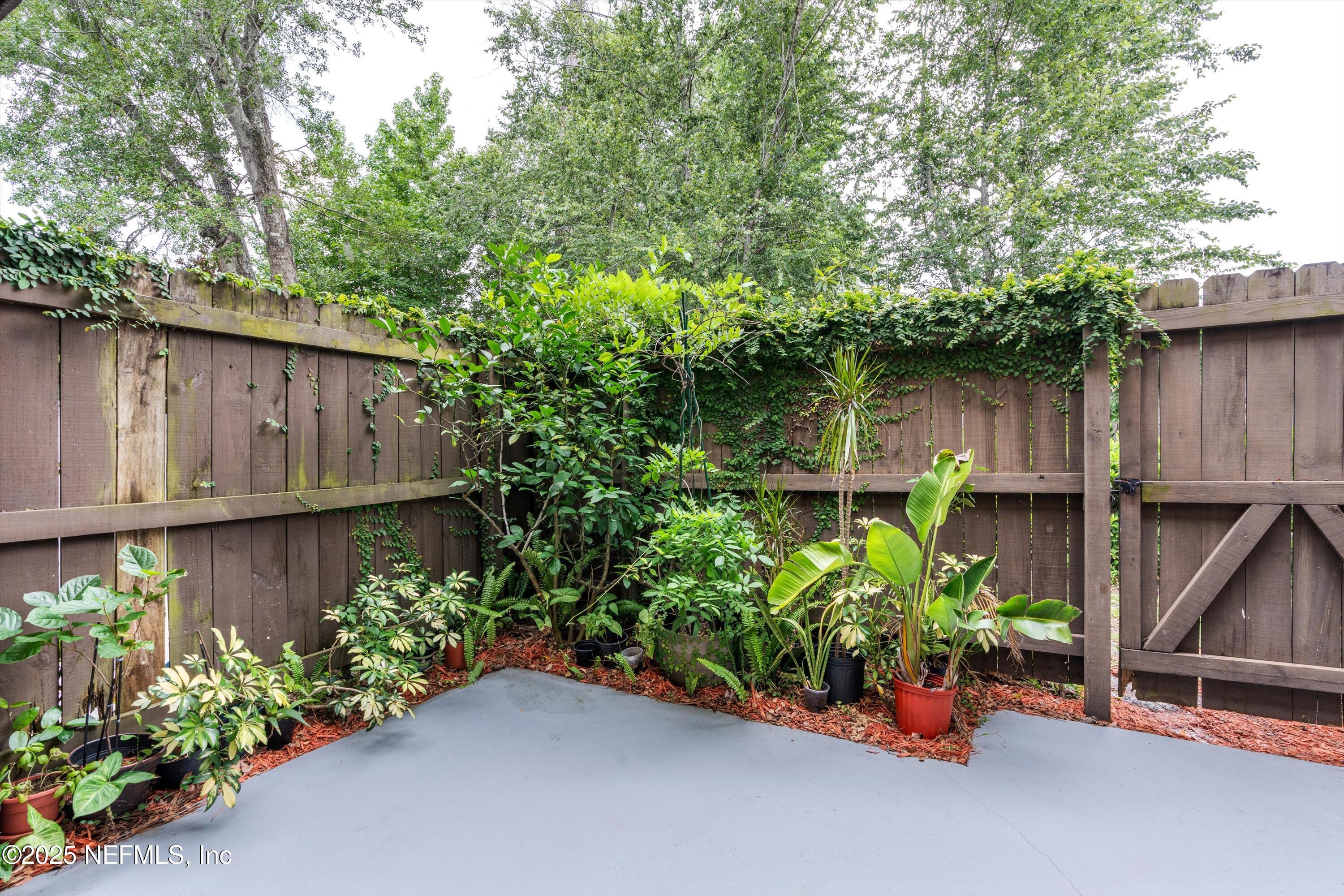 4807 Evenlode Lane Jacksonville, FL 32217 - Photo 20 of 28 a wooden fence with some potted plants and a bench