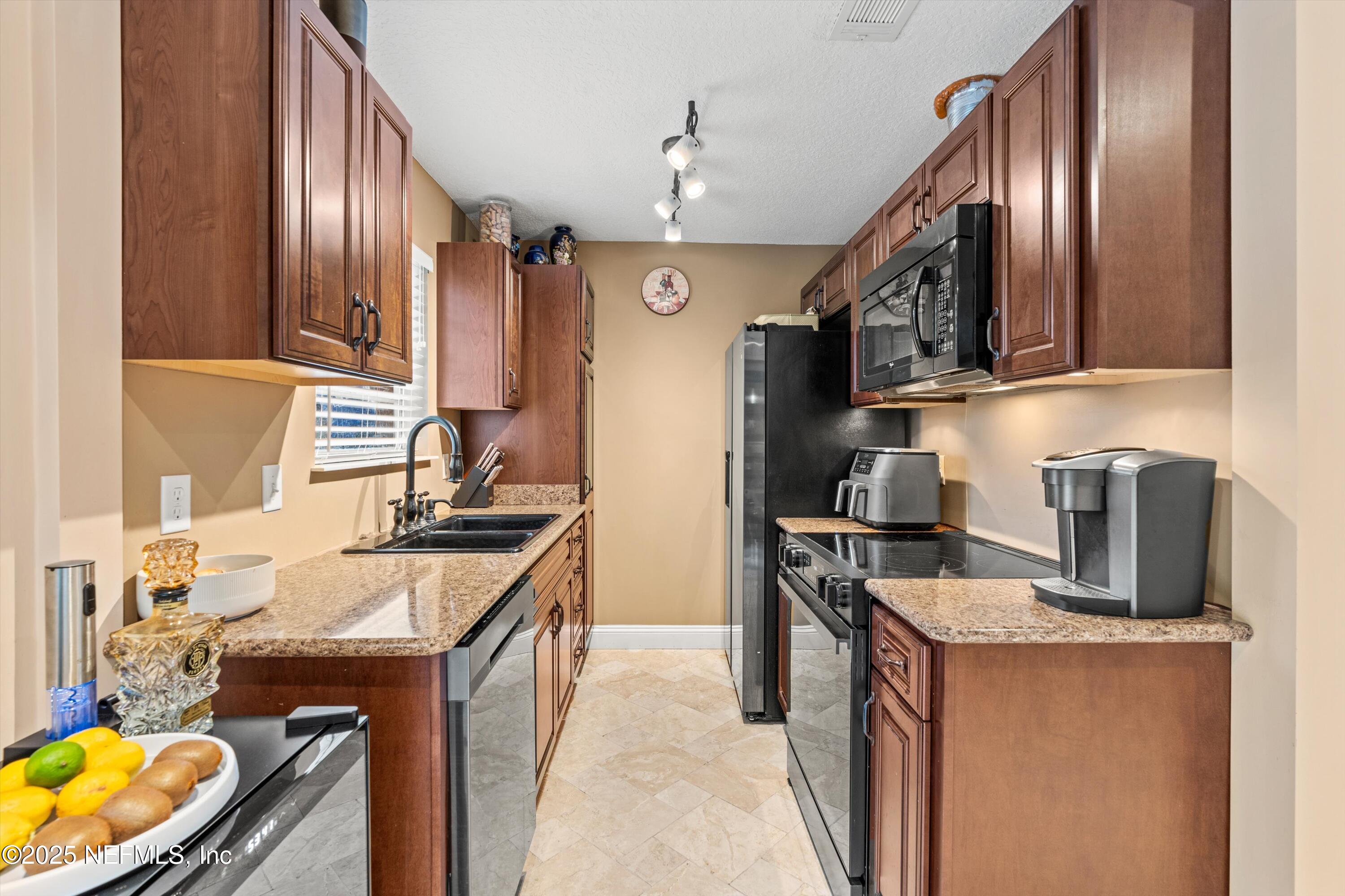 4807 Evenlode Lane Jacksonville, FL 32217 - Photo 7 of 28 a kitchen with stainless steel appliances granite countertop a sink stove and refrigerator