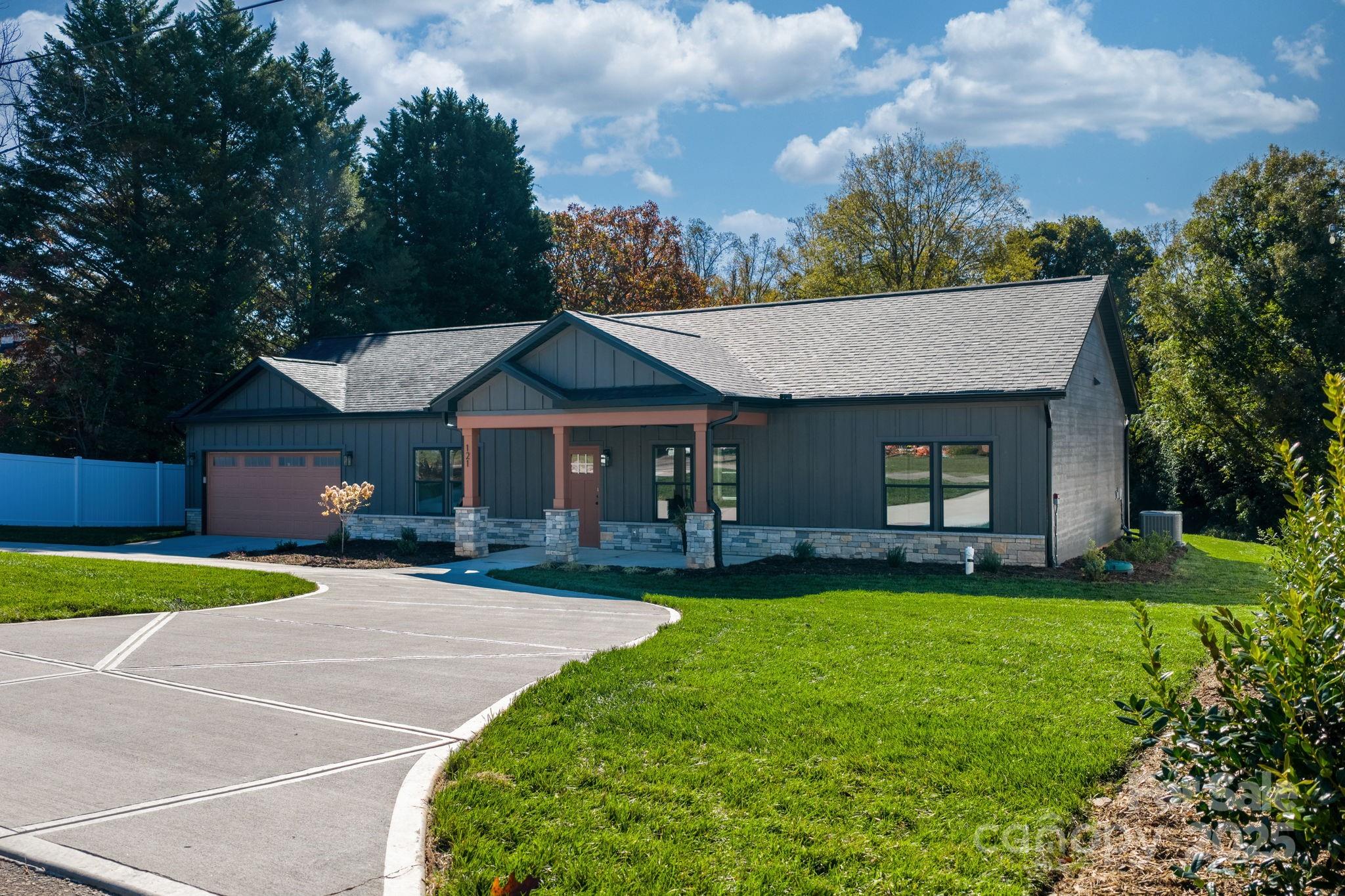 a front view of a house with a garden and trees