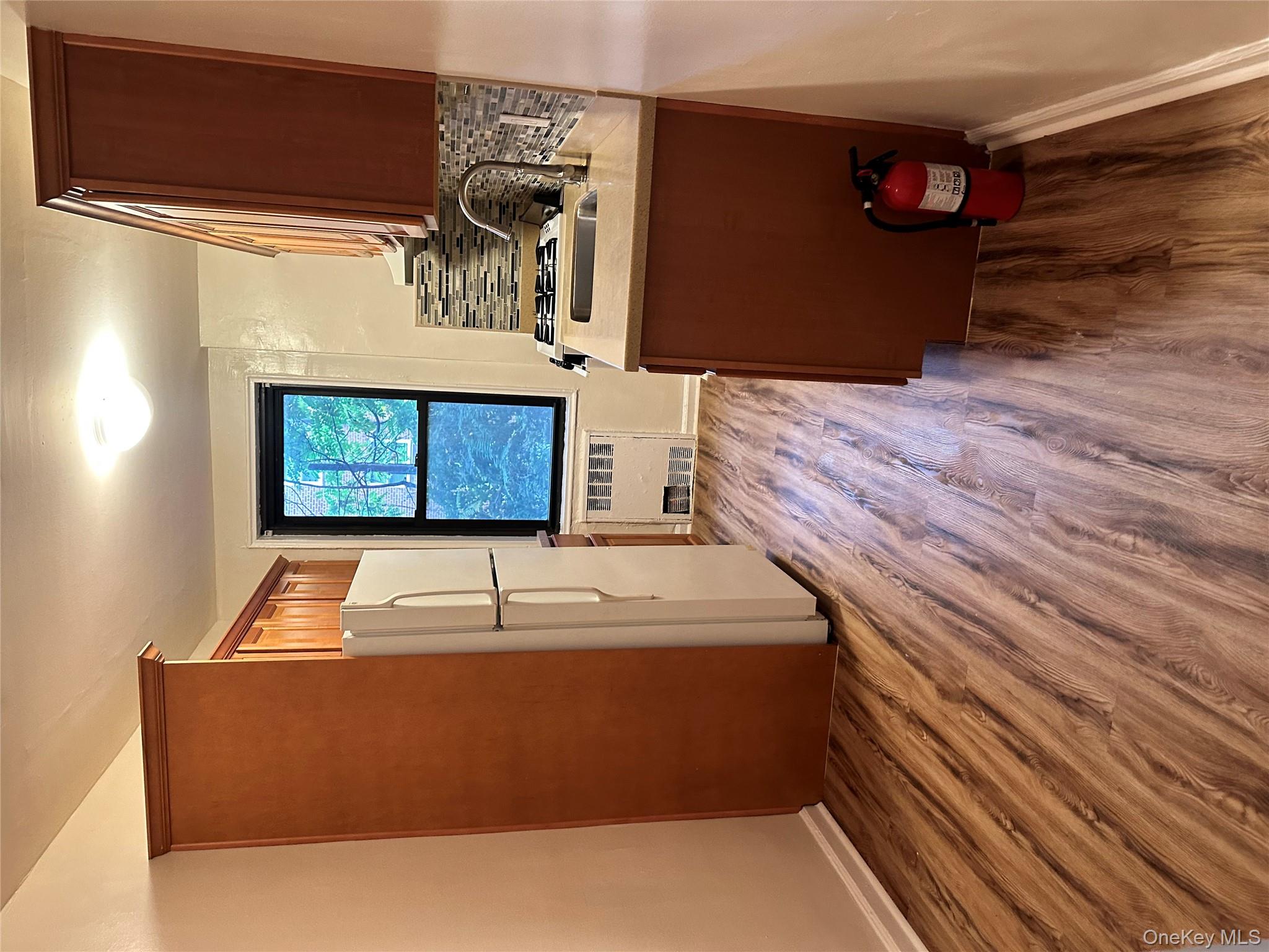 150-25 72nd Road, Unit 1J Queens, NY 11367 - Photo 14 of 14 a kitchen with stainless steel appliances granite countertop a refrigerator a stove and a wooden floors