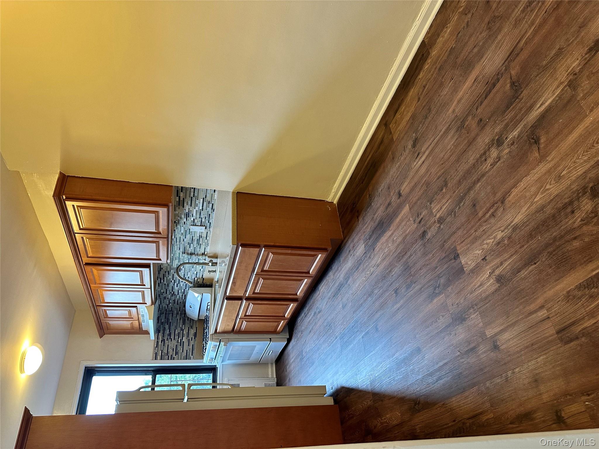150-25 72nd Road, Unit 1J Queens, NY 11367 - Photo 6 of 14 a kitchen with stainless steel appliances granite countertop a stove and wooden floor