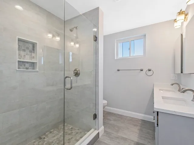 a bathroom with a shower sink and mirror