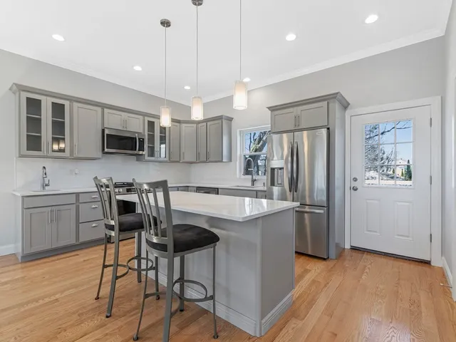 a kitchen with kitchen island a refrigerator stove microwave and cabinets