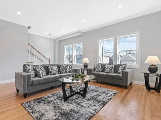 a living room with furniture a rug and a window