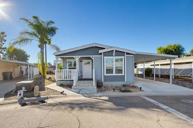 a front view of a house with porch and seating space