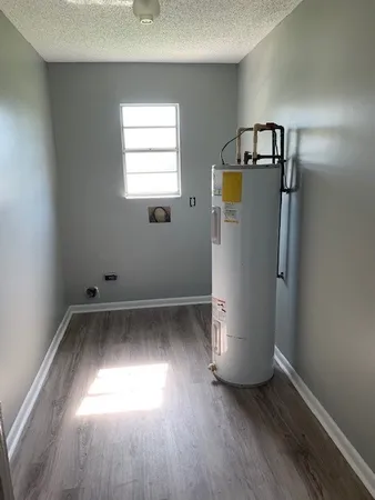 a view of empty room with wooden floor and window