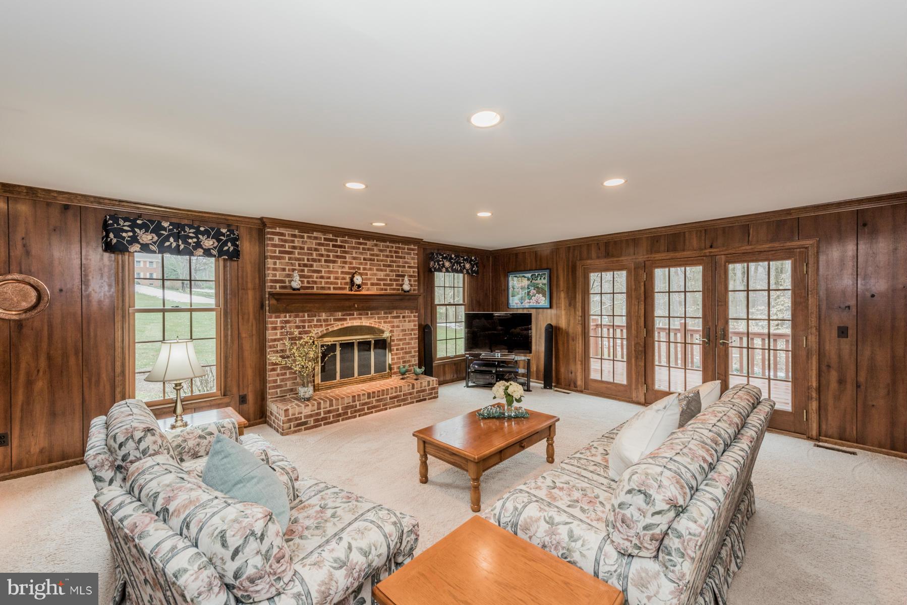 5 Wetherbee Court Phoenix, MD 21131 - Photo 11 of 29 a living room with furniture a fireplace and a floor to ceiling window