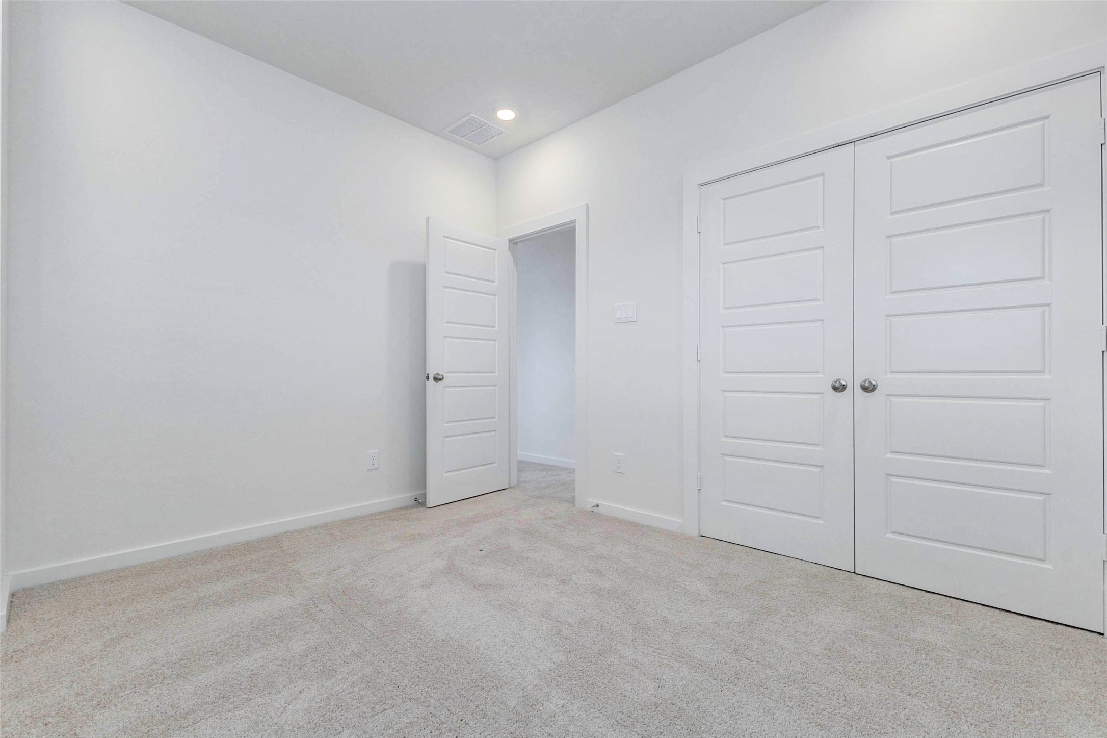 6471 Escondido Drive Rosharon, TX 77583 - Photo 27 of 33 Secondary bedroom with neutral carpet, white walls, recessed lighting, and double closet doors for convenient storage. The clean, move-in-ready design provides a versatile space that can easily serve as a guest room, child’s bedroom, home office, or quiet retreat.