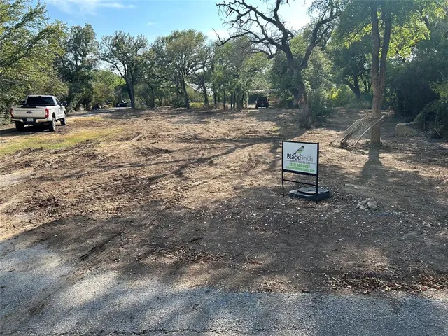 a view of a backyard with table and chairs a fire pit and a large tree