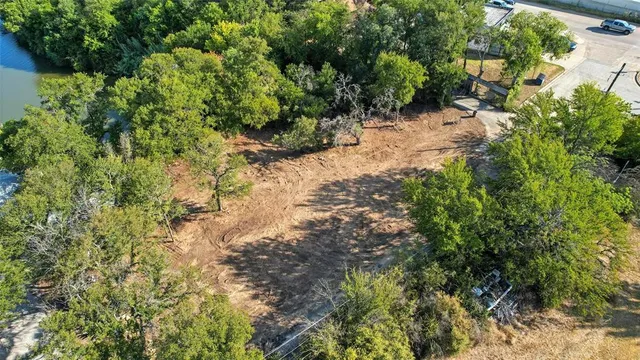 an aerial view of residential houses with outdoor space and trees all around