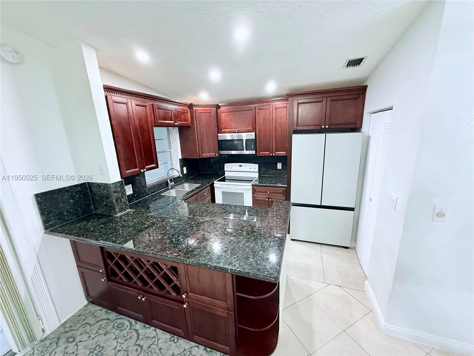 22279 Woodborn Drive Boca Raton, FL 33428 - Photo 6 of 19 a kitchen with stainless steel appliances granite countertop a refrigerator sink and stove