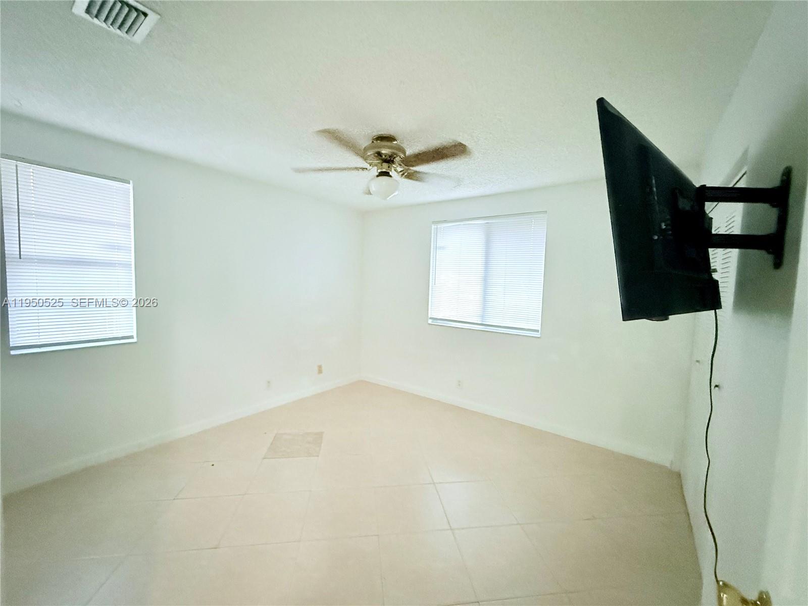 22279 Woodborn Drive Boca Raton, FL 33428 - Photo 10 of 19 an empty room with windows and fan