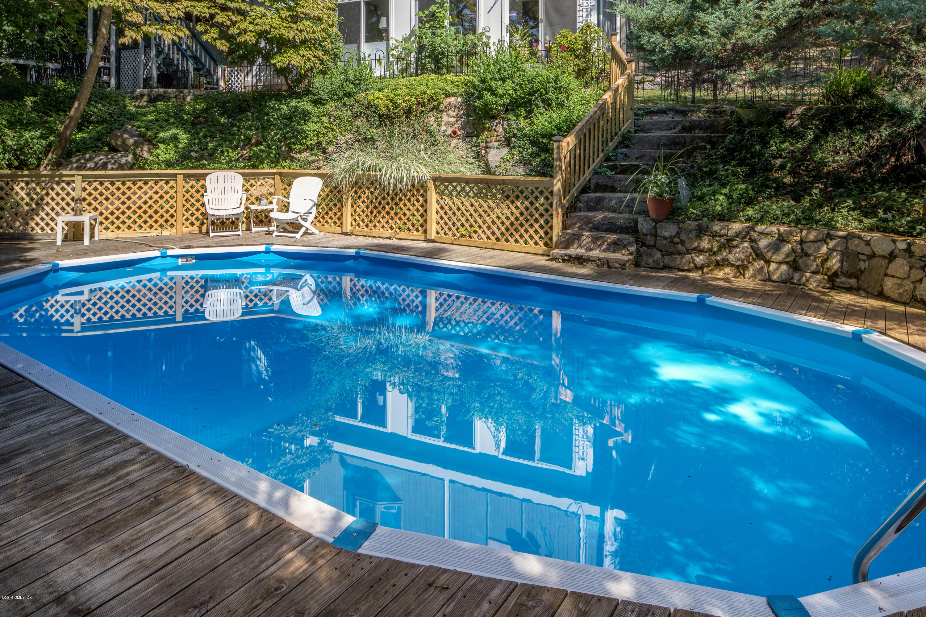 7 Crawford Terrace Riverside, CT 06878 - Photo 16 of 19 a view of swimming pool with a chair and floor to ceiling window and wooden fence
