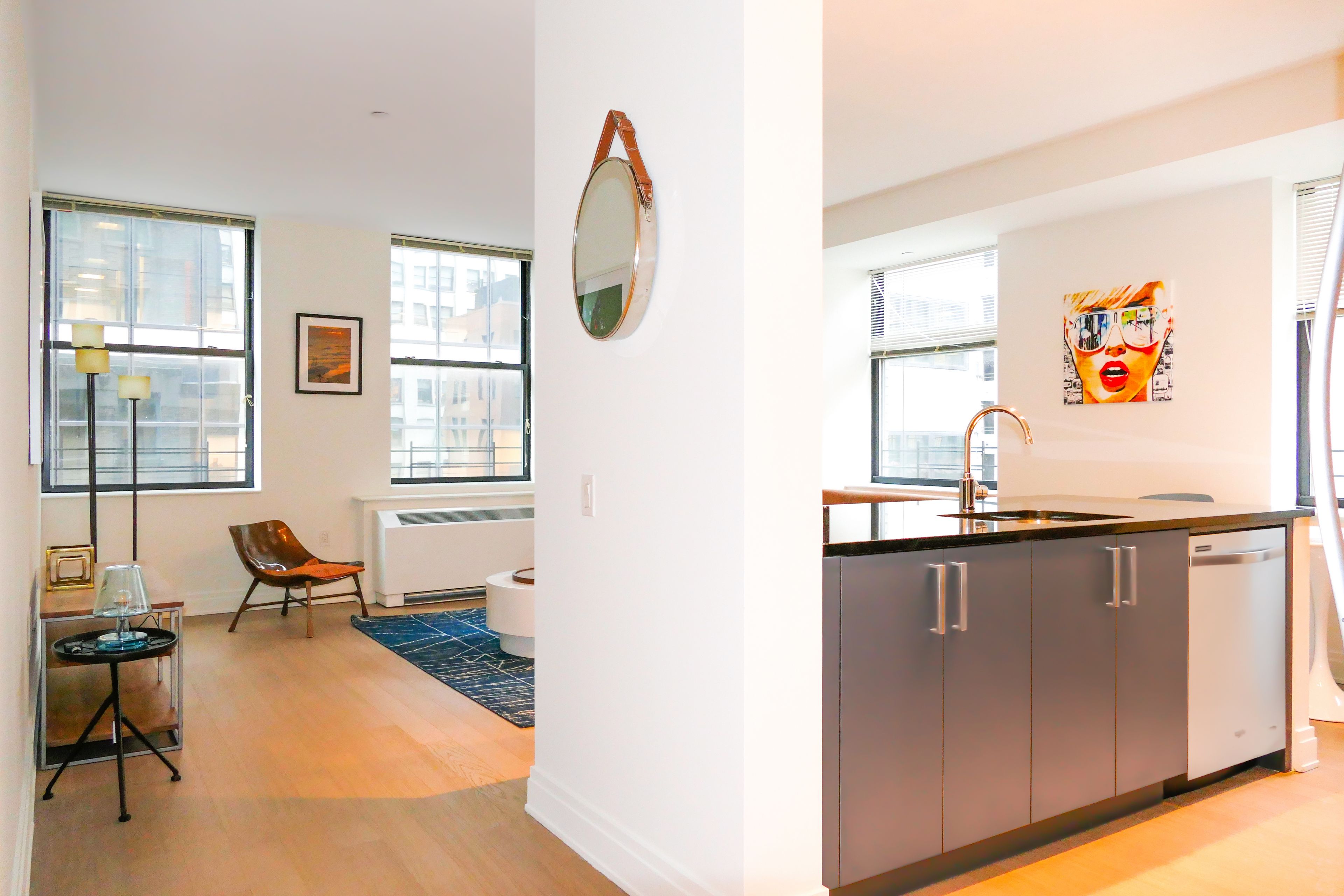 70 Pine Street, Unit 1802 Manhattan, NY 10005 - Photo 3 of 27 a living room with furniture a window and a sink