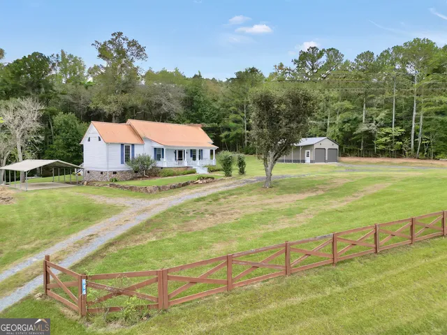 an aerial view of a house with a yard and lake view